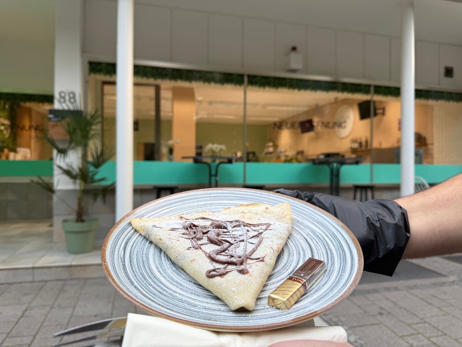 Ein frisch servierter VIVA-Crêpe auf einem Teller vor unserem Laden